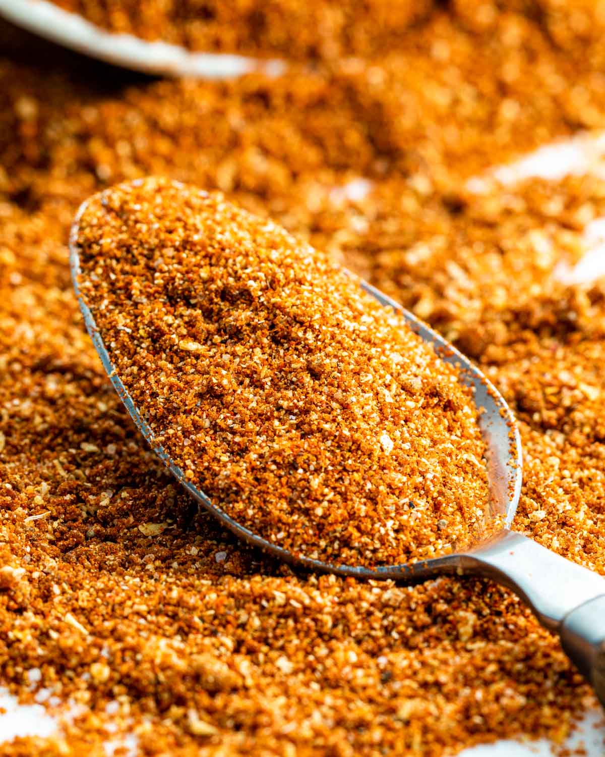 closeup sideview shot of a tablespoon with bbq dry rub surround by it