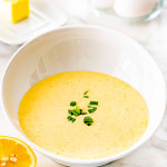 freshly made hollandaise sauce in a white bowl garnished with chives