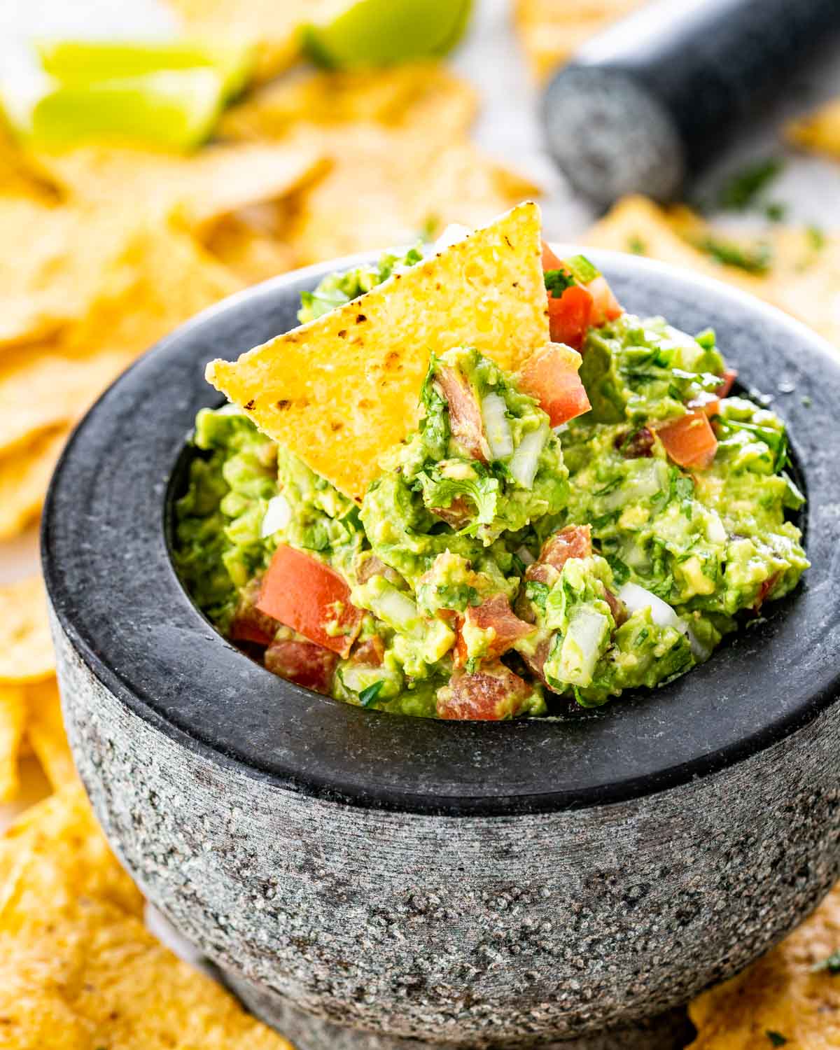 a bowl with guacamole in it and a tortilla chip on top