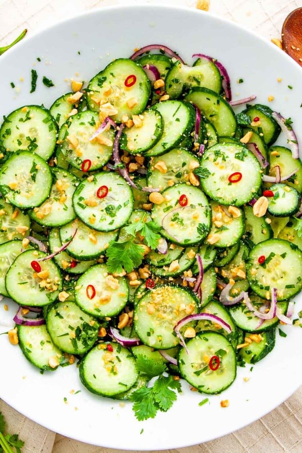 overhead shot of thai cucumber salad freshly made in a white plate