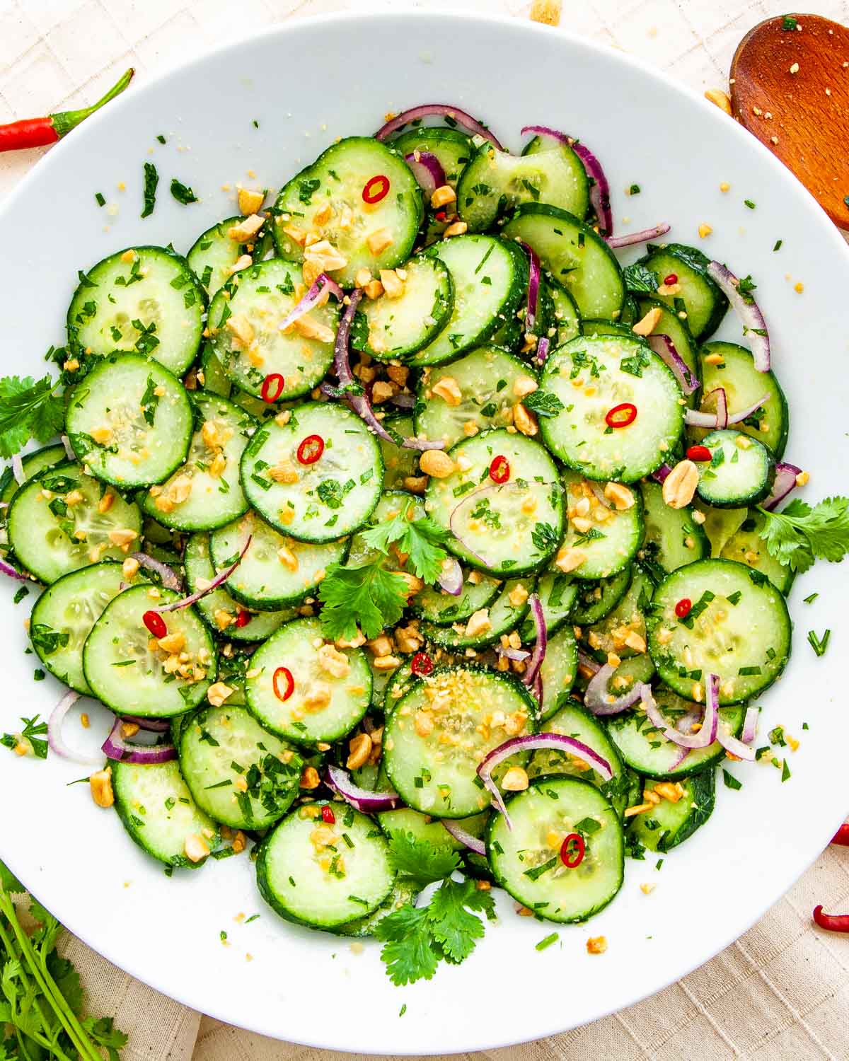 overhead shot of thai cucumber salad freshly made in a white plate