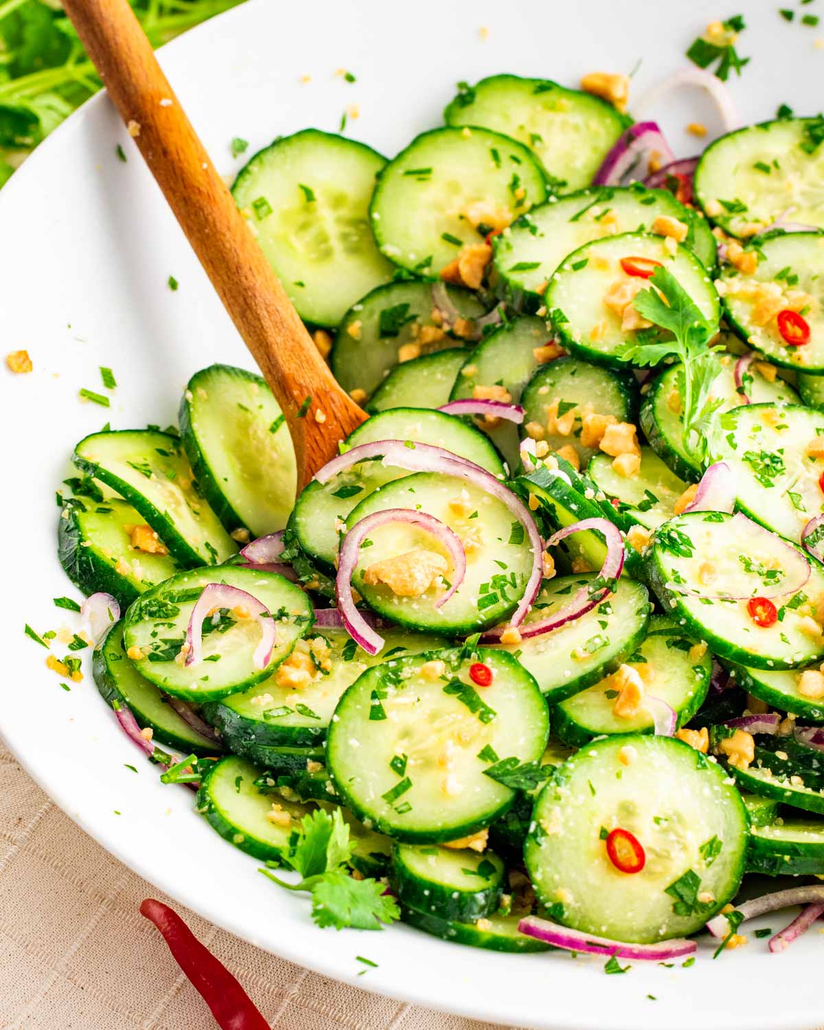 thai cucumber salad with a wooden spoon inside