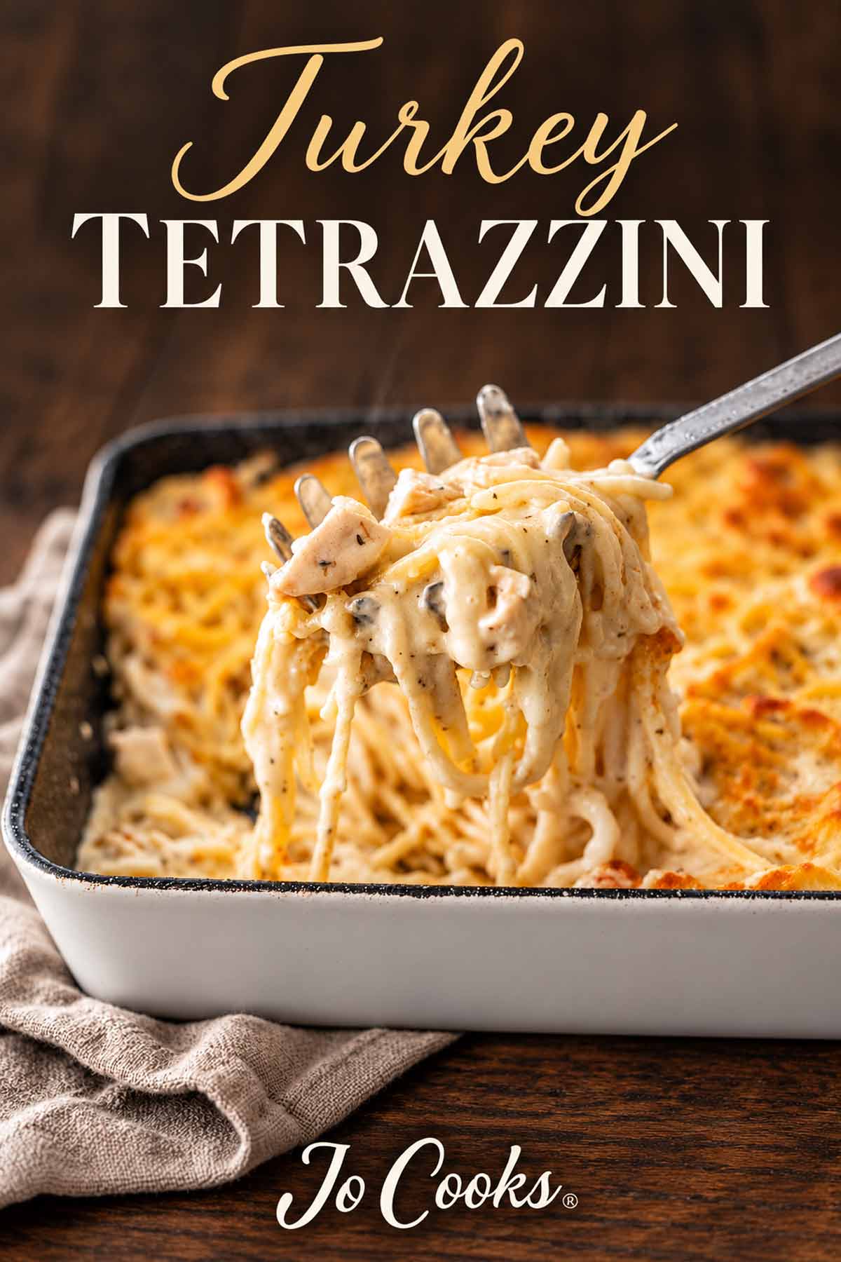 Creamy turkey tetrazzini lifted from a baking dish, beneath gold and ivory recipe lettering, with the Jo Cooks logo below.