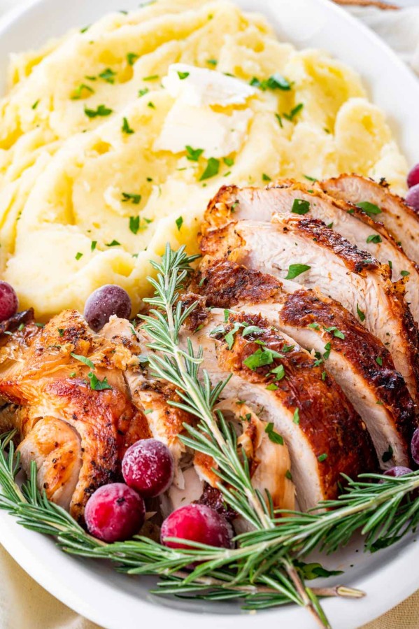 sliced turkey breast next to mashed potaotes.