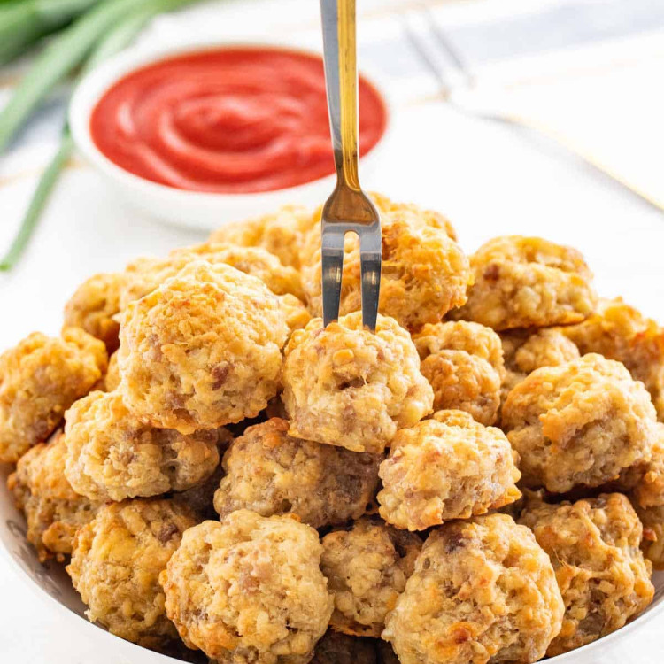 a bowl of sausage balls with a cocktail fork stuck in one