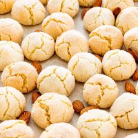a bunch of amaretti cookies on parchment paper with almonds.