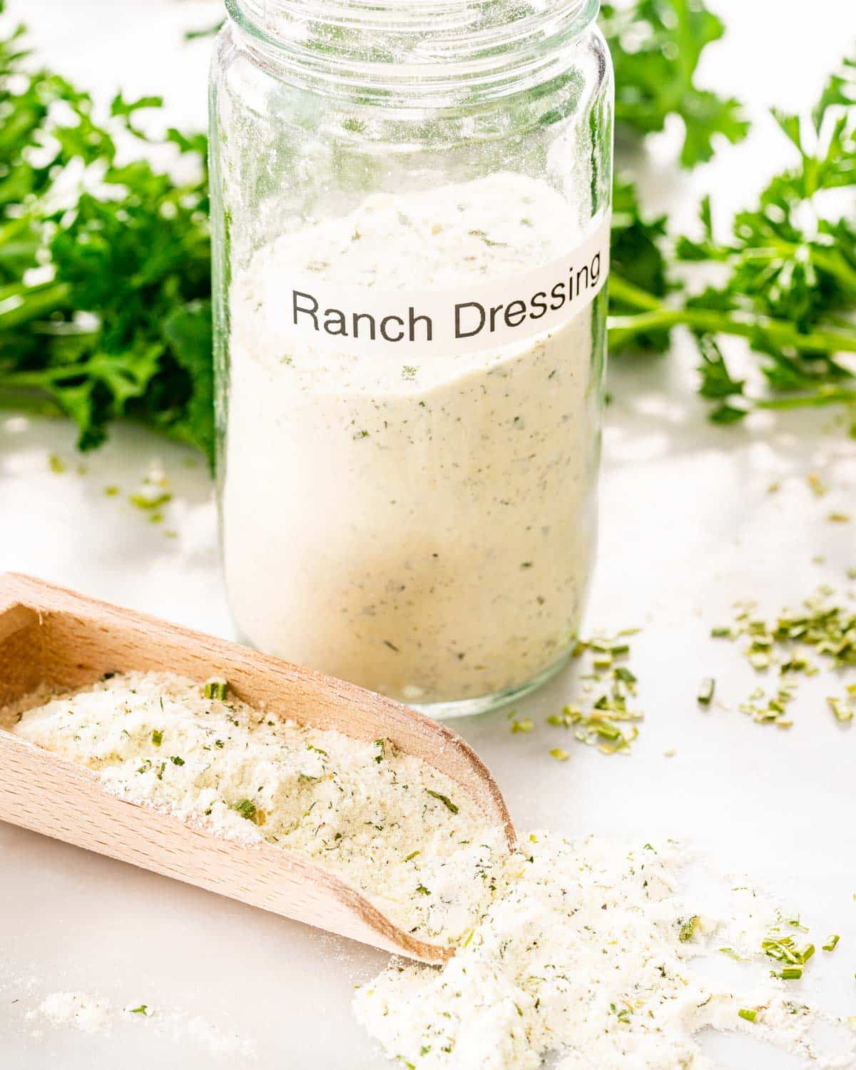 a jar with homemade ranch dressing mix and a scoop.