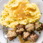 overhead shot of meatballs with mashed potatoes and gravy on a plate.