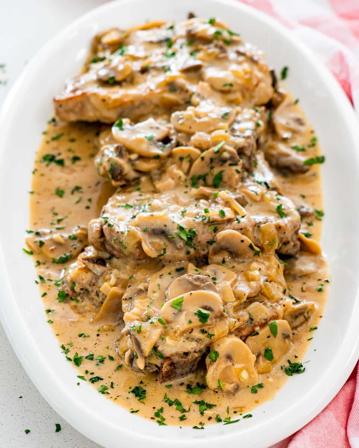 pork chops with mushroom gravy on a serving platter.