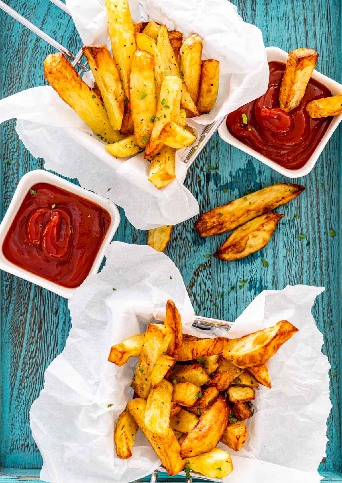 french fries in a basket with a small bowl with ketchup.