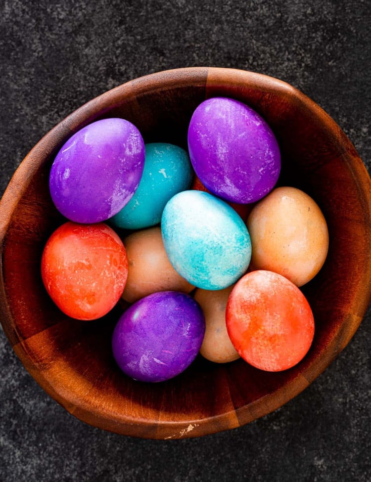 overhead shot of easter eggs in a wooden basket.