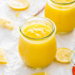lemon curd in little jars with lemon slices around.
