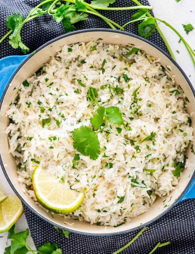 cilantro lime rice in a pot garnished with cilantro and lime wedge.