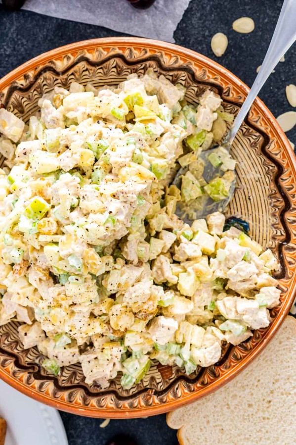 curry chicken salad in a bowl with a serving spoon inside.
