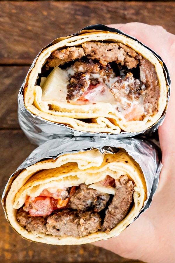 two halves of halifax donair held in a hand.
