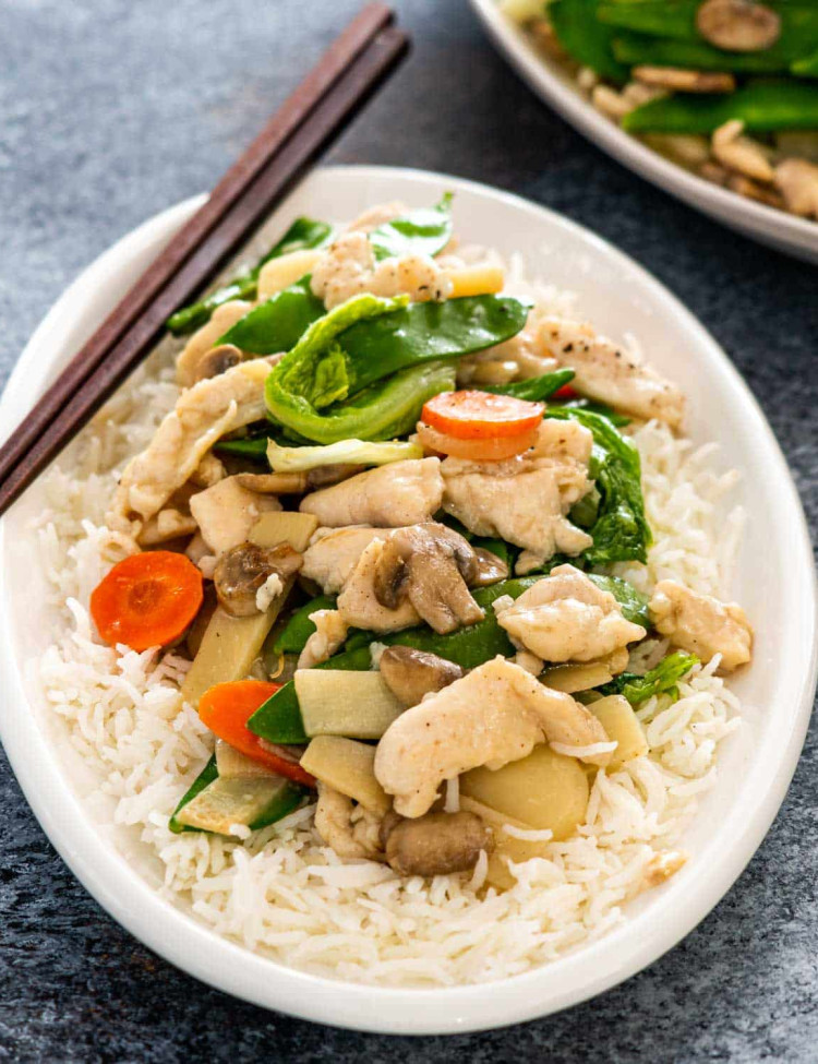 moo goo gai pan over rice on a white plate.