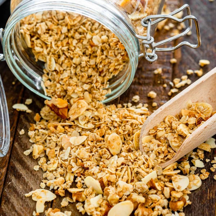 a jar with granola spilled over on a board.