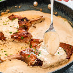 spooning peppercorn sauce over pork chops in a skillet.
