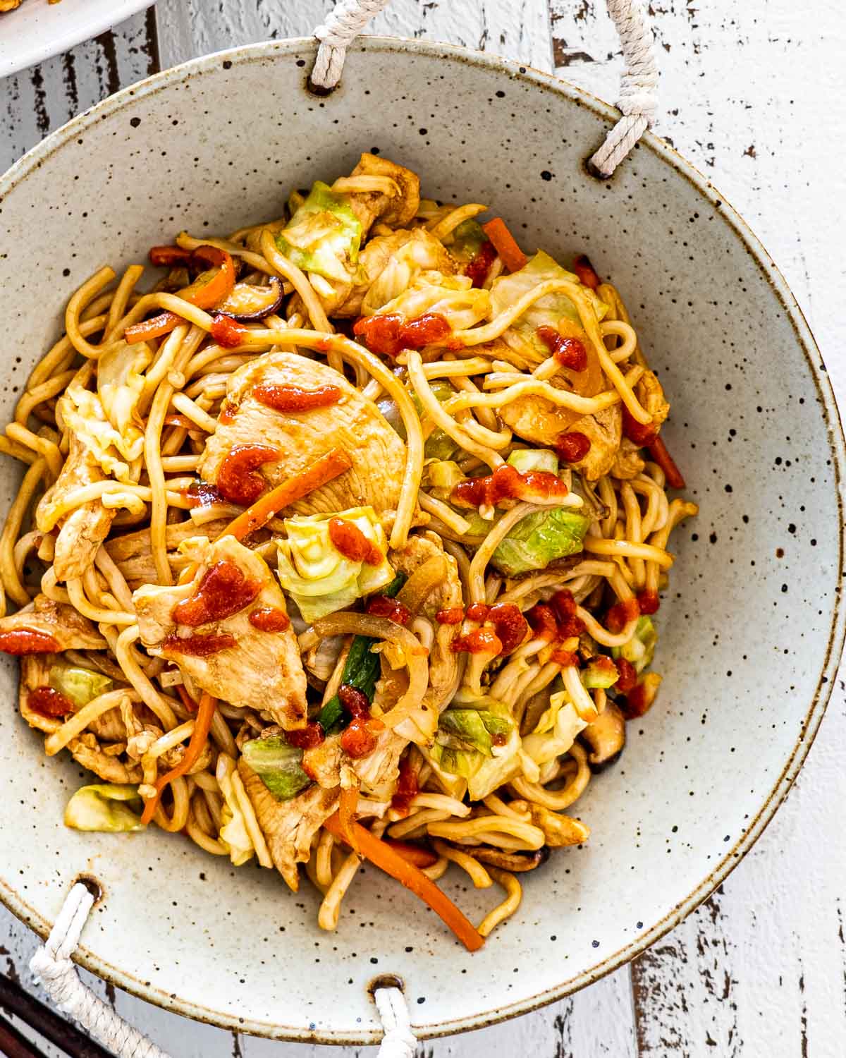 overhead yakisoba noodles with chicken on a plate.