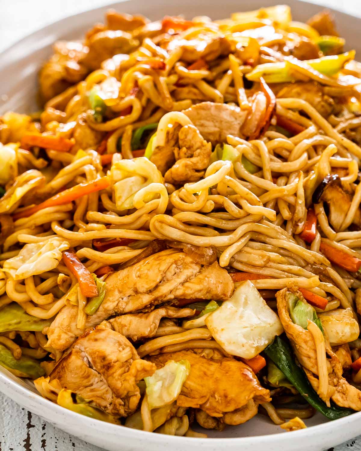 yakisoba noodles with chicken and vegetables in a large serving platter.