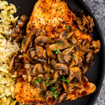 jagerschnitzel with spaetzle on a black plate garnished with parsley.