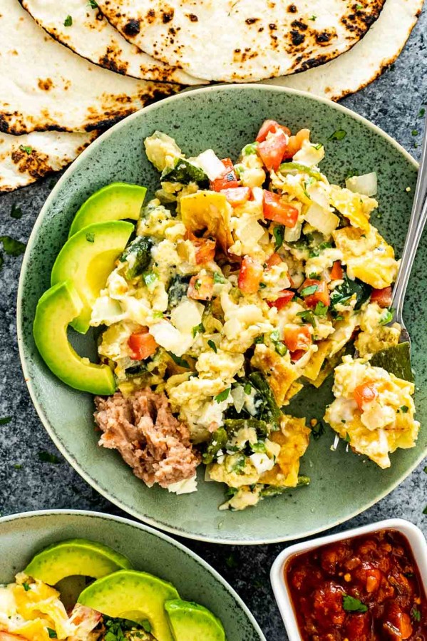 migas in a green plate with some toasted tortillas.
