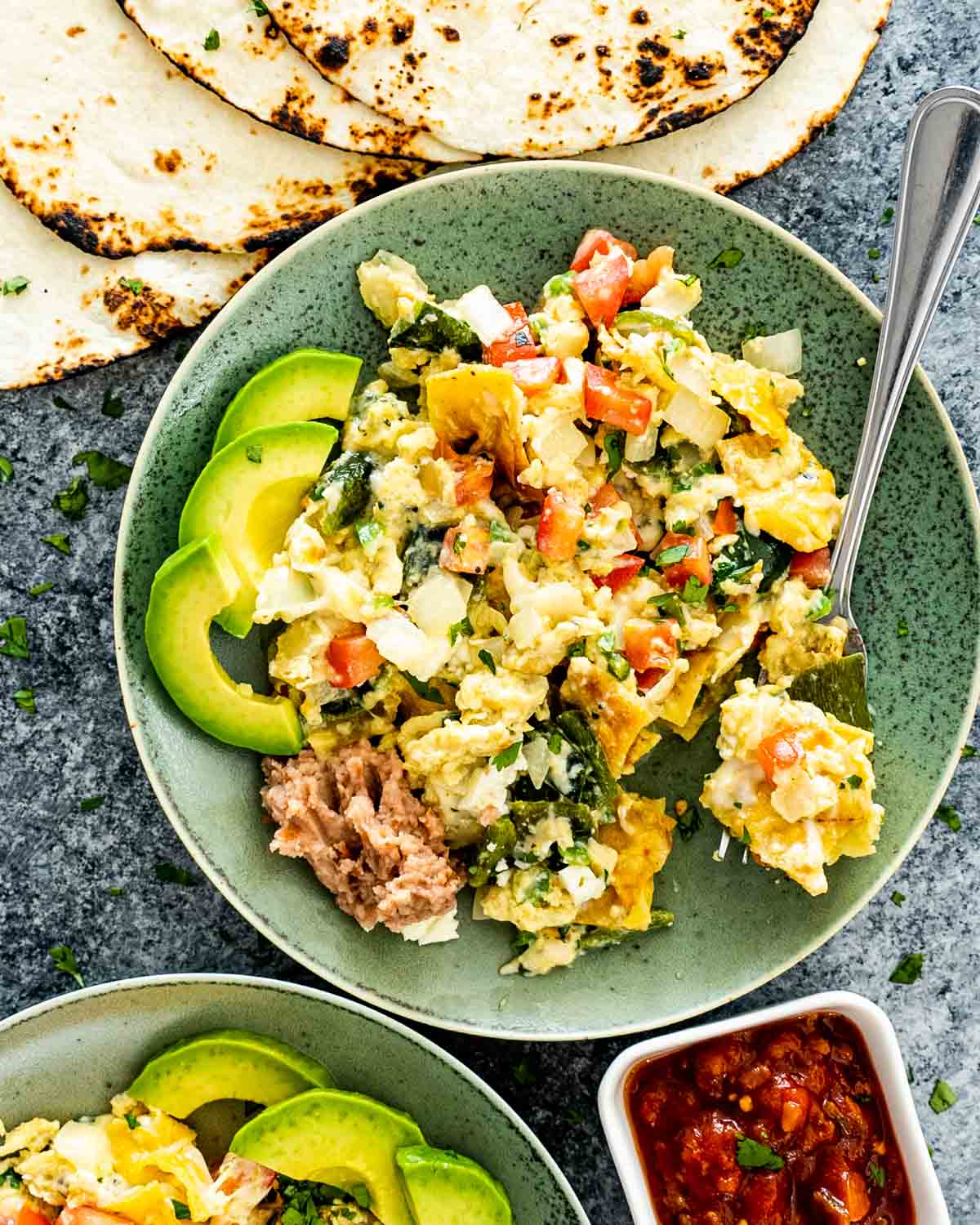 migas in a green plate with some toasted tortillas.