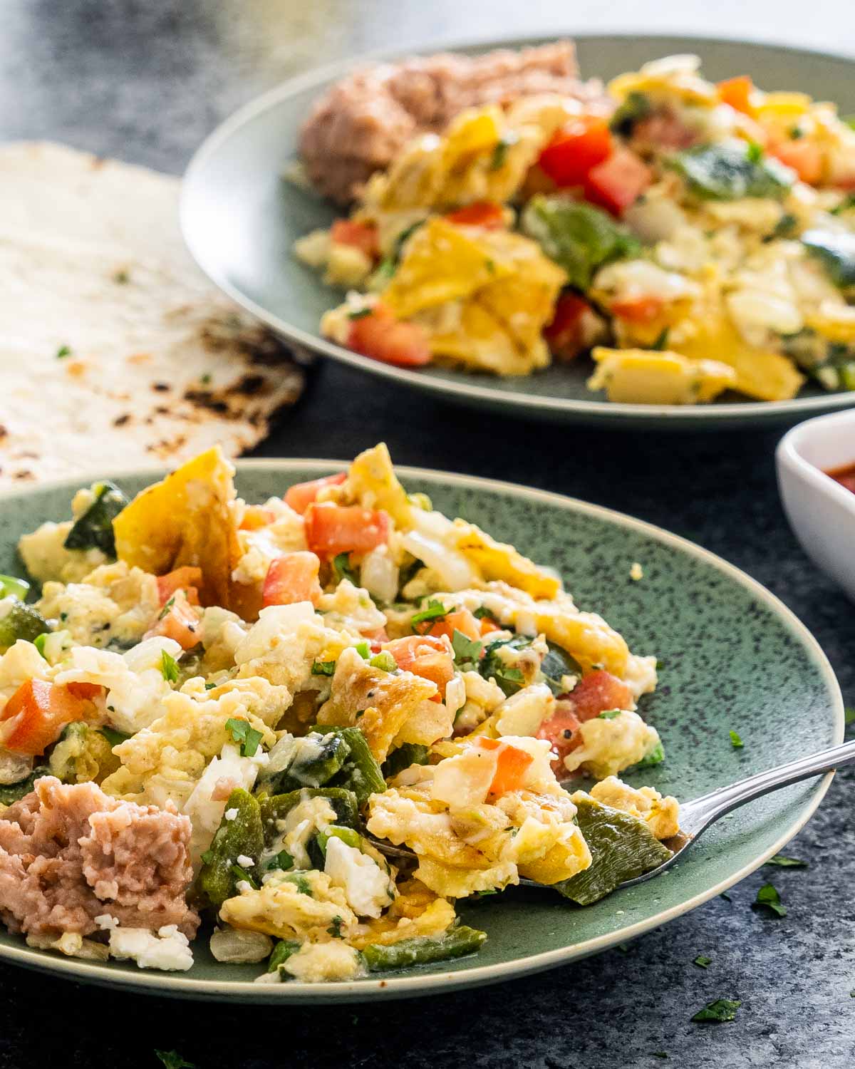 migas in a green plate with a fork.
