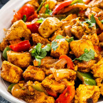 chicken jalfrezi on a white silver platter.