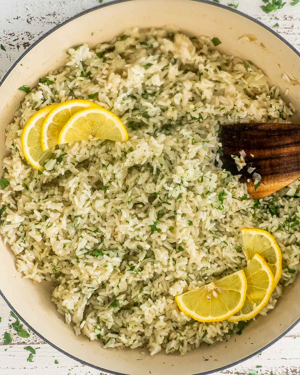 greek rice in a pot garnished with lemon slices.