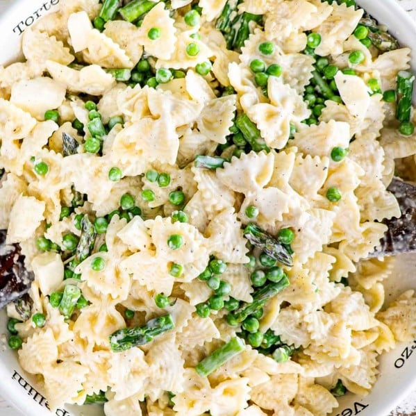 asparagus and peas pasta salad in a white pasta bowl.