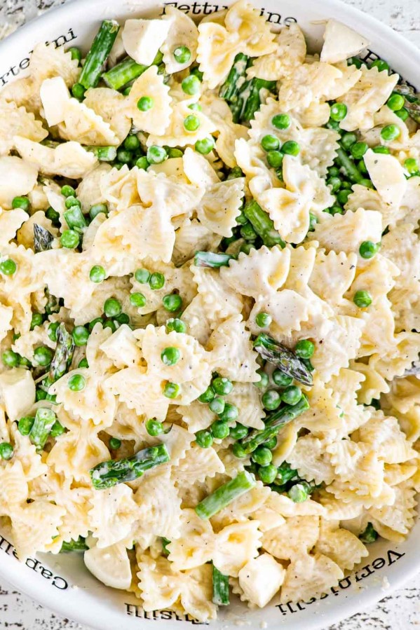 asparagus and peas pasta salad in a white pasta bowl.