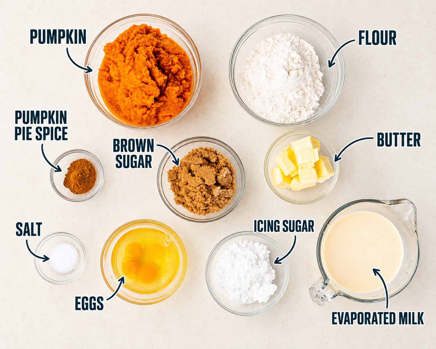 Labeled pumpkin pie bar ingredients: pumpkin, flour, butter, brown sugar, icing sugar, eggs, evaporated milk, salt, and pumpkin pie spice.