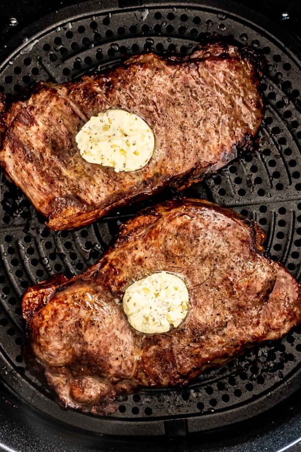 2 steaks with butter in an air fryer.