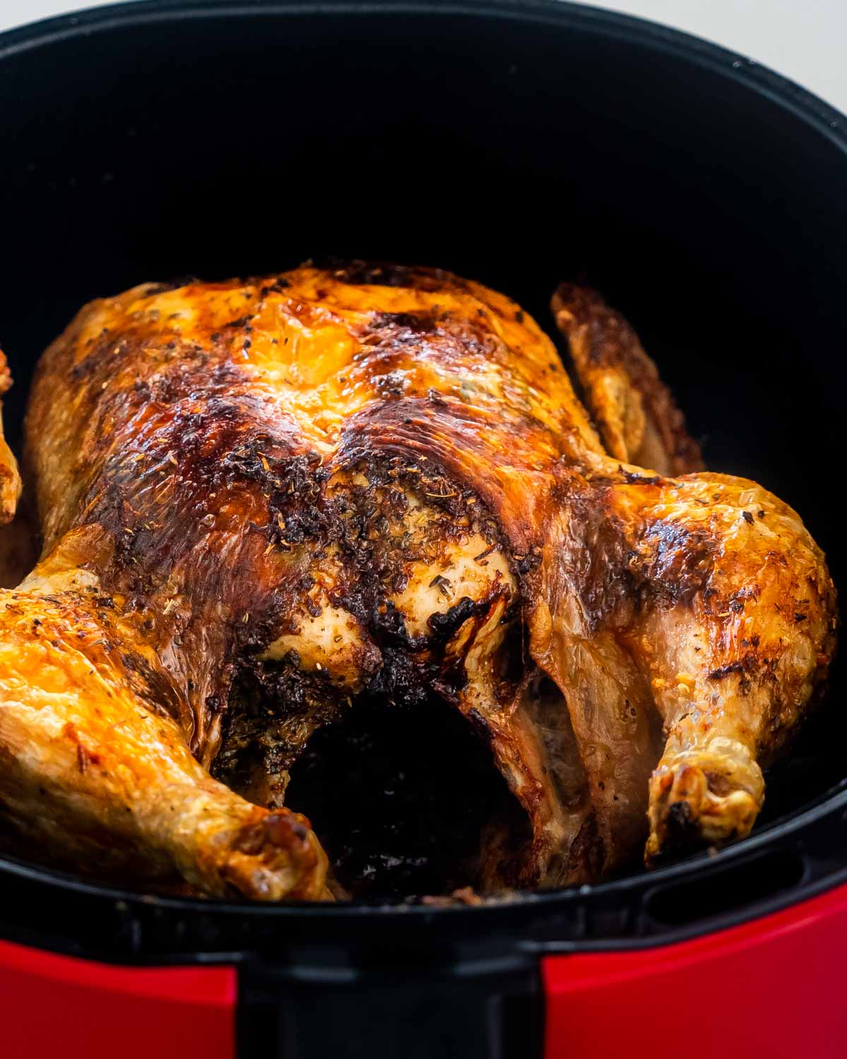 a roasted whole chicken in an air fryer.