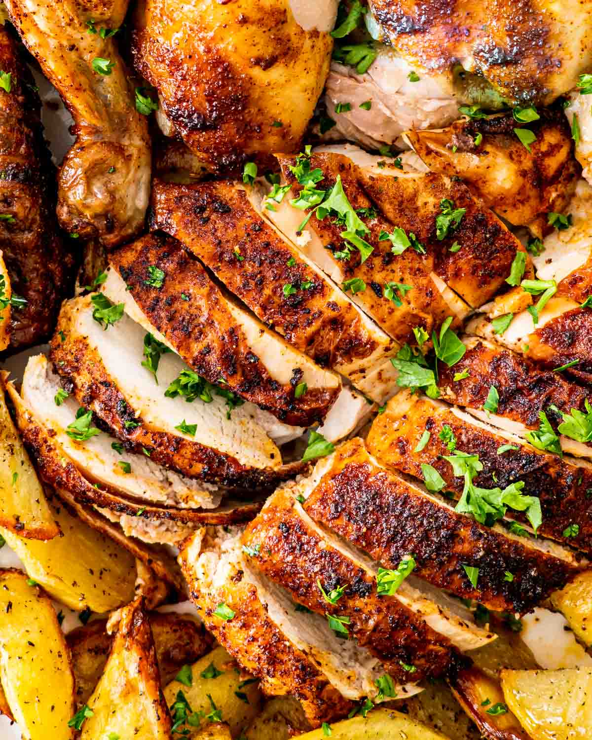 cut up roasted chicken breasts garnished with parsley.