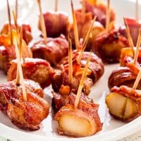 bacon wrapped water chestnuts on a white serving platter.