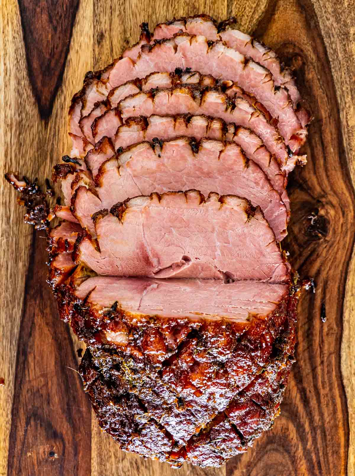 sliced up bourbon glazed baked ham on a cutting board.