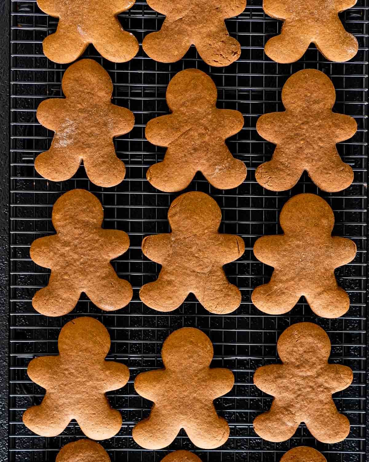 gingerbread cookies on a black cooling rack.