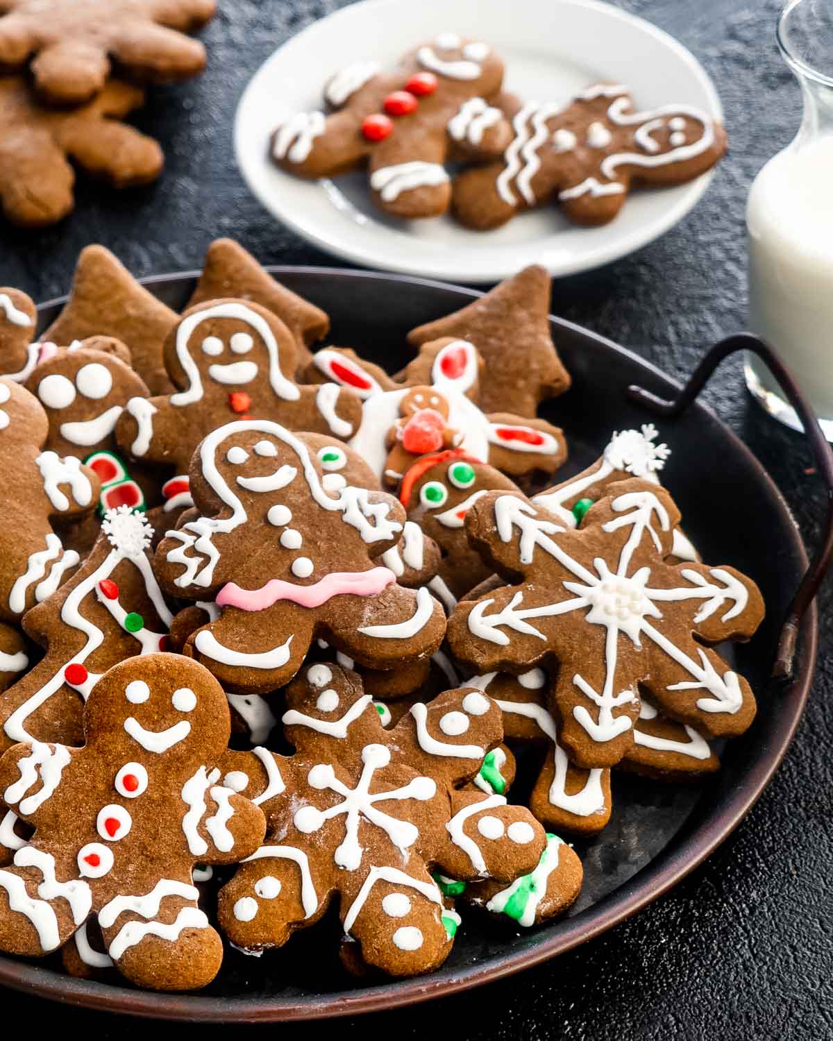 beautifully decorated gingerbread cooking on a plate with a glass of milk for santa.