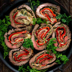 slices of italian stuffed flank steak on a serving platter.