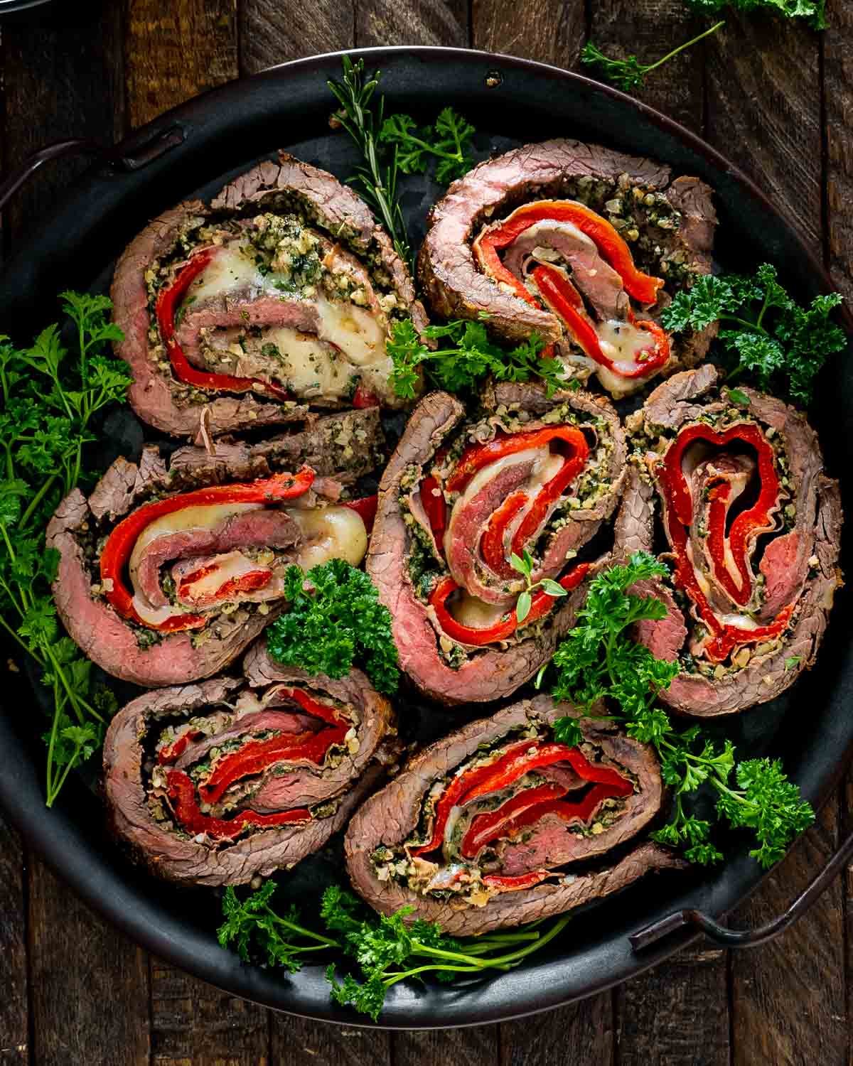 slices of italian stuffed flank steak on a serving platter.