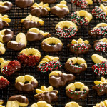 beautifully decorated spritz cookies on a cooling rack.