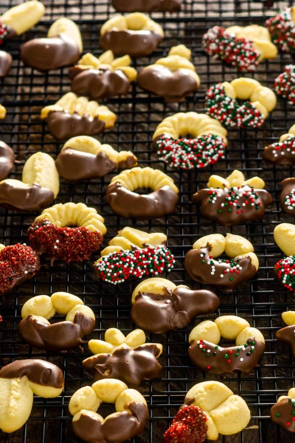 beautifully decorated spritz cookies on a cooling rack.