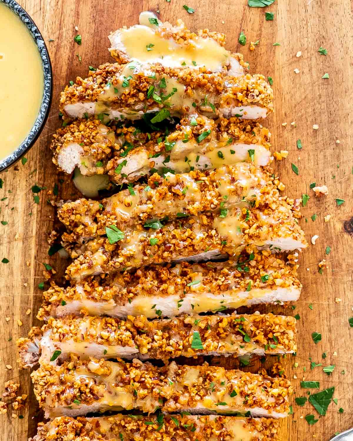 pecan crusted chicken on a cutting board sliced up.
