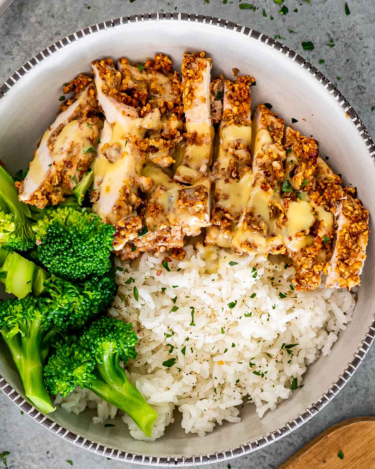 sliced pecan crusted chicken with rice and broccoli.