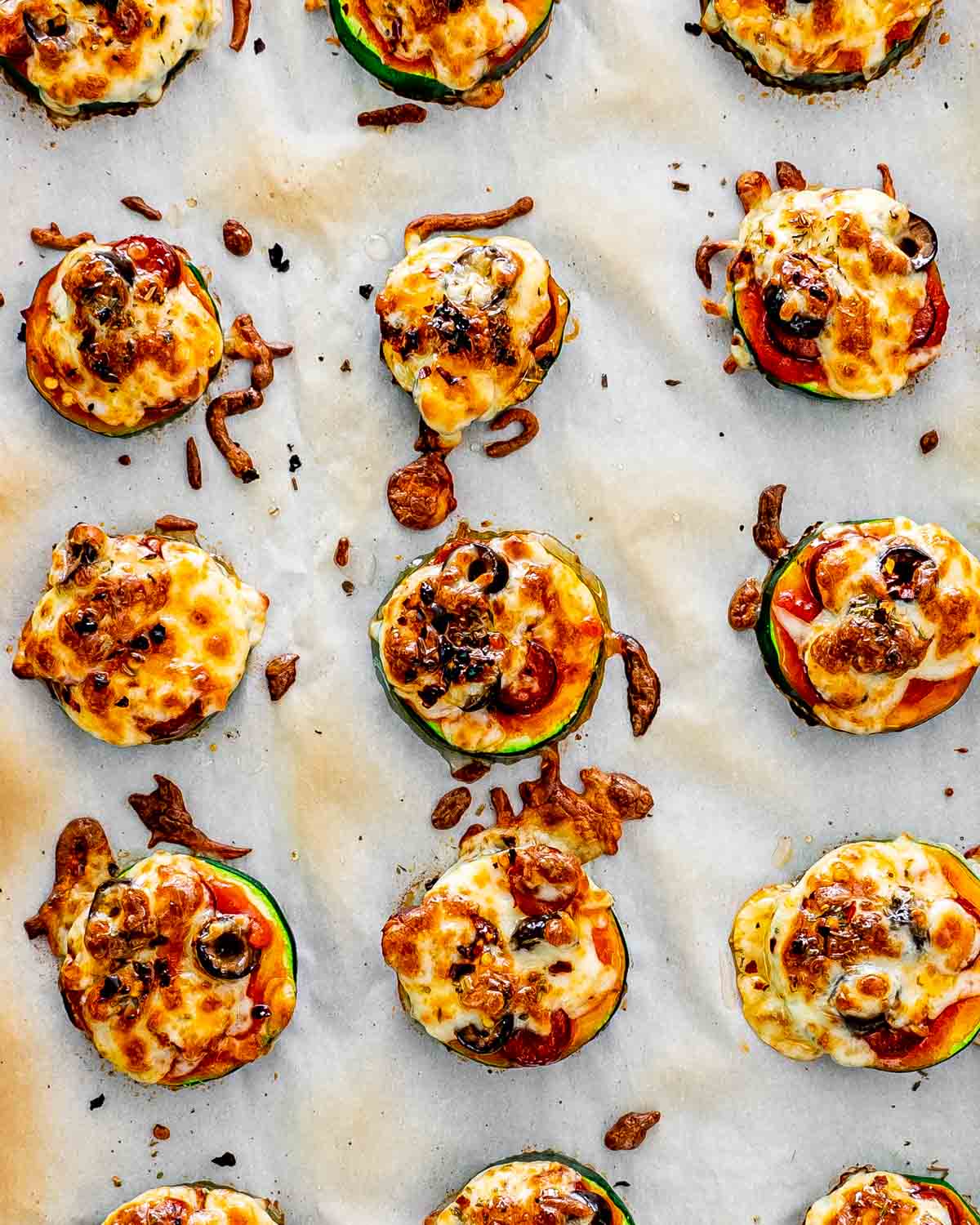 zucchini pizza bites on a baking sheet lined with parchment paper.