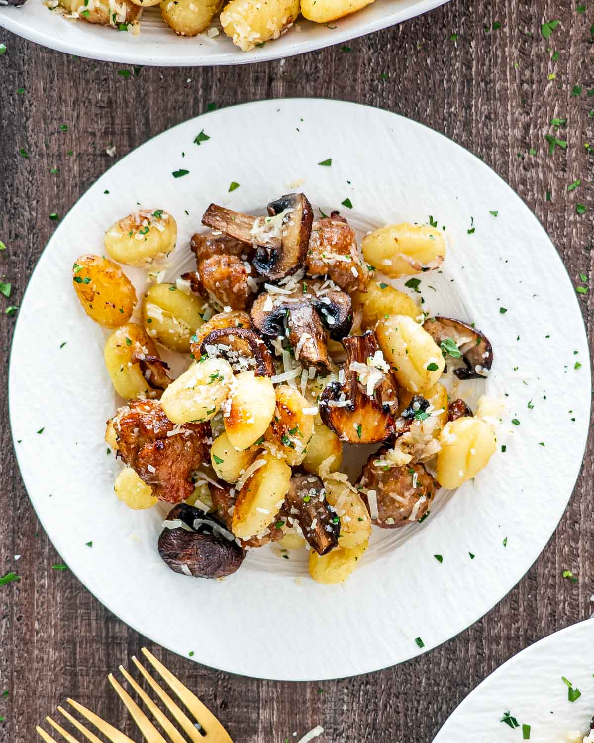 a serving of mushroom sausage gnocchi on a white plate.