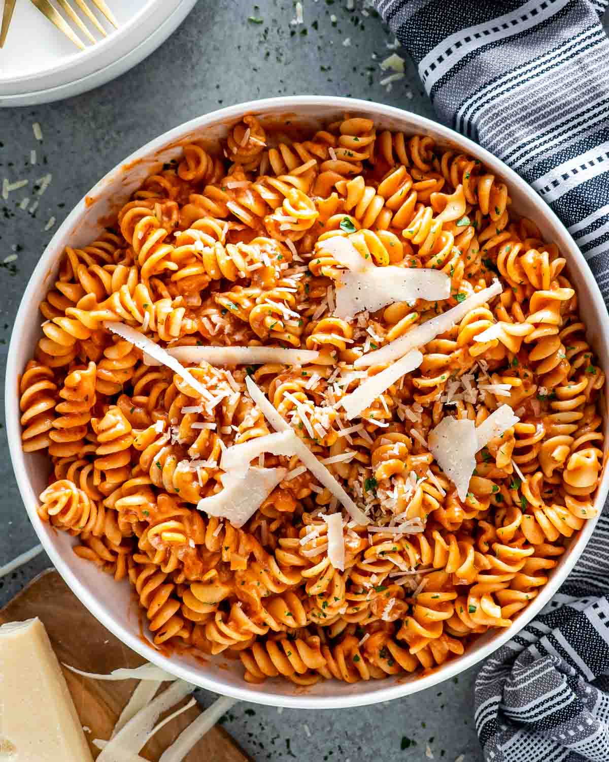 rigatoni fiorentina in a white bowl with a bit of parmesan cheese.