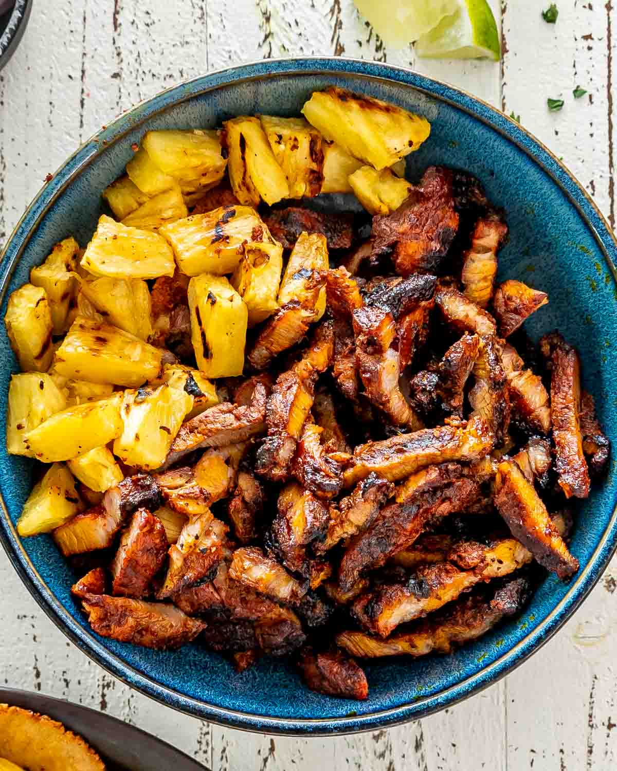 sliced up grilled meat and pineapple for making tacos al pastor.